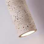 Close view of the lit end of this Clérachic travertine pendant, with the porous stone texture visible around the glowing opening.