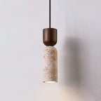 Clérachic pendant seen slightly further back, walnut cap over a veined beige stone cylinder, glowing warmly at the base.