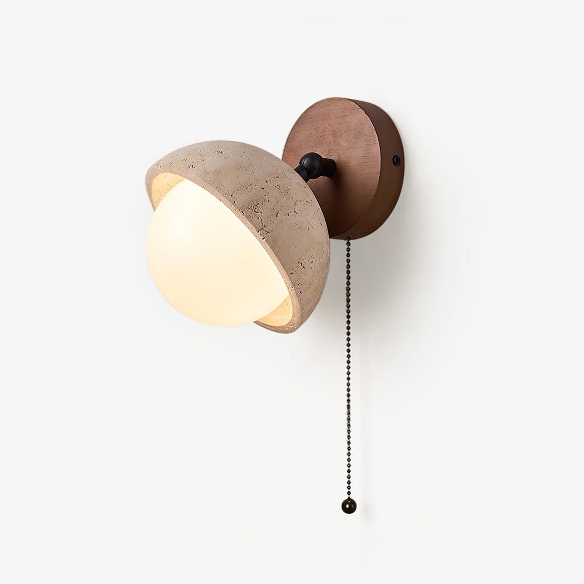 Single travertine dome wall light from Clérachic, with a frosted white glass globe, a walnut backplate and a black pull chain, on white.