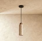 A round travertine pendant by Clérachic glows softly from below, its wood cap and stone cylinder catching warm light.