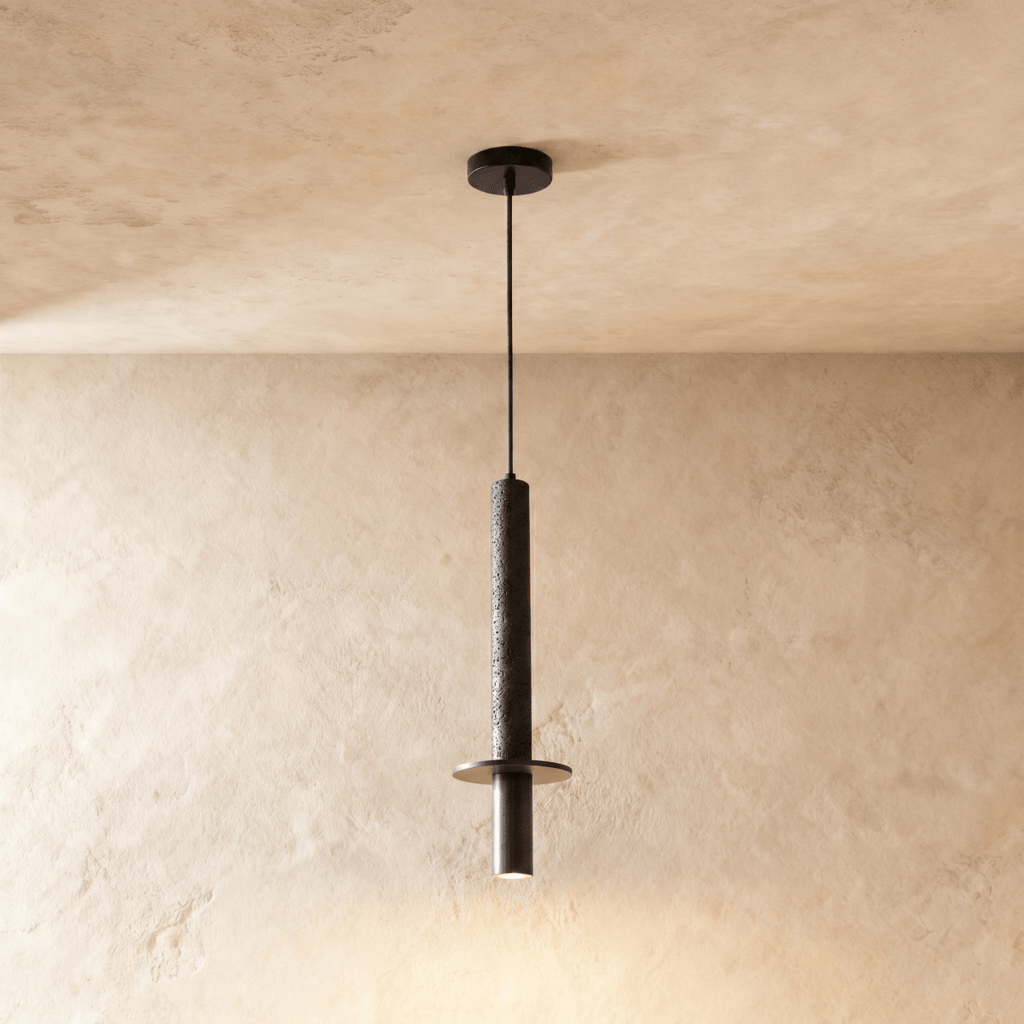 This Clérachic pendant light drops a textured stone-finish cylinder and steel spotlight cap from the ceiling.