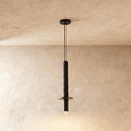 This Clérachic pendant light drops a textured stone-finish cylinder and steel spotlight cap from the ceiling.
