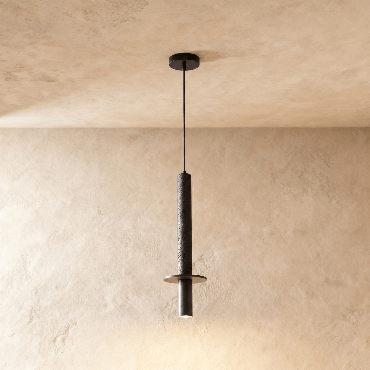 This Clérachic pendant light drops a textured stone-finish cylinder and steel spotlight cap from the ceiling.