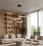 This Clérachic ring pendant cluster hangs in front of a lit wooden bookcase, above a beige sofa and a round stone coffee table.