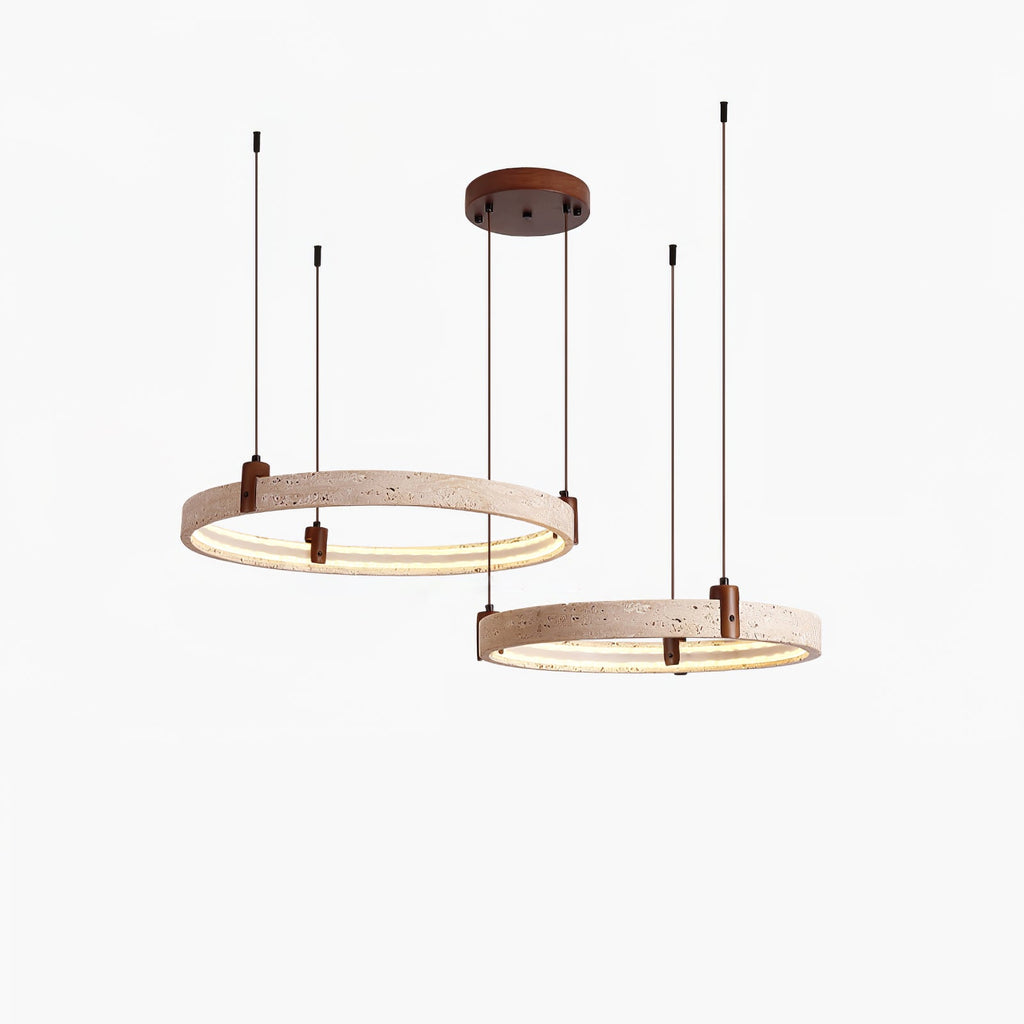 A two-ring version of this Clérachic travertine pendant hangs from a round canopy, each ring lit warm on its inner edge.