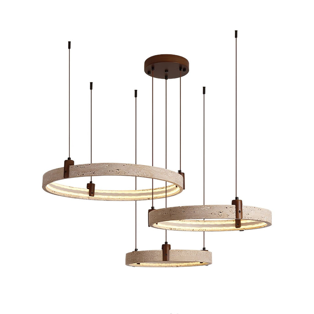 Three travertine rings on a Clérachic pendant, lit warm and hung at different heights from a round canopy, on white.