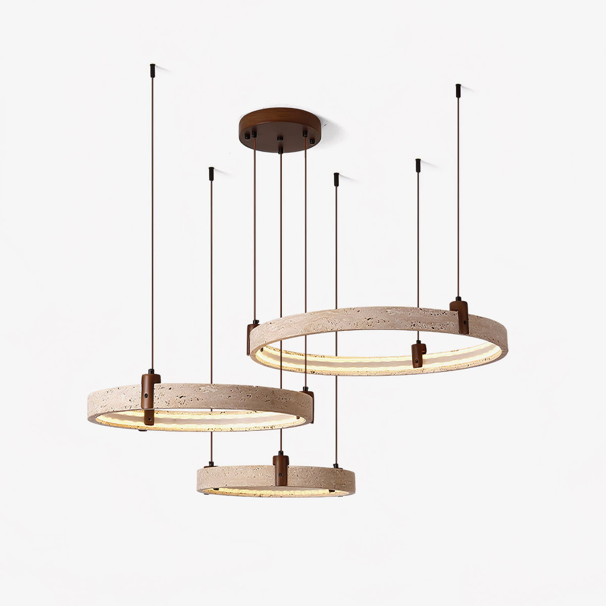 Cords of different lengths hold three glowing travertine rings on this Clérachic pendant, shown on a pale studio backdrop.