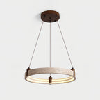 Warm light runs around the inner edge of this Clérachic travertine ring pendant, which hangs on cords from a round canopy, on light grey.