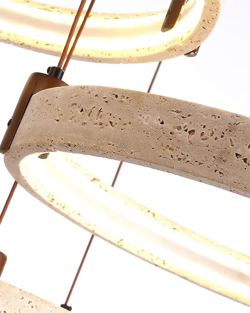 Tight view of a lit travertine ring on a Clérachic pendant, with a pitted stone face, a walnut bracket and a warm light band.
