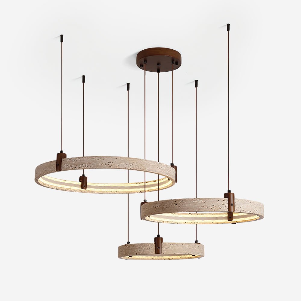 Three travertine rings with warm light inside hang from a round canopy on this Clérachic pendant, shown on an off-white backdrop.