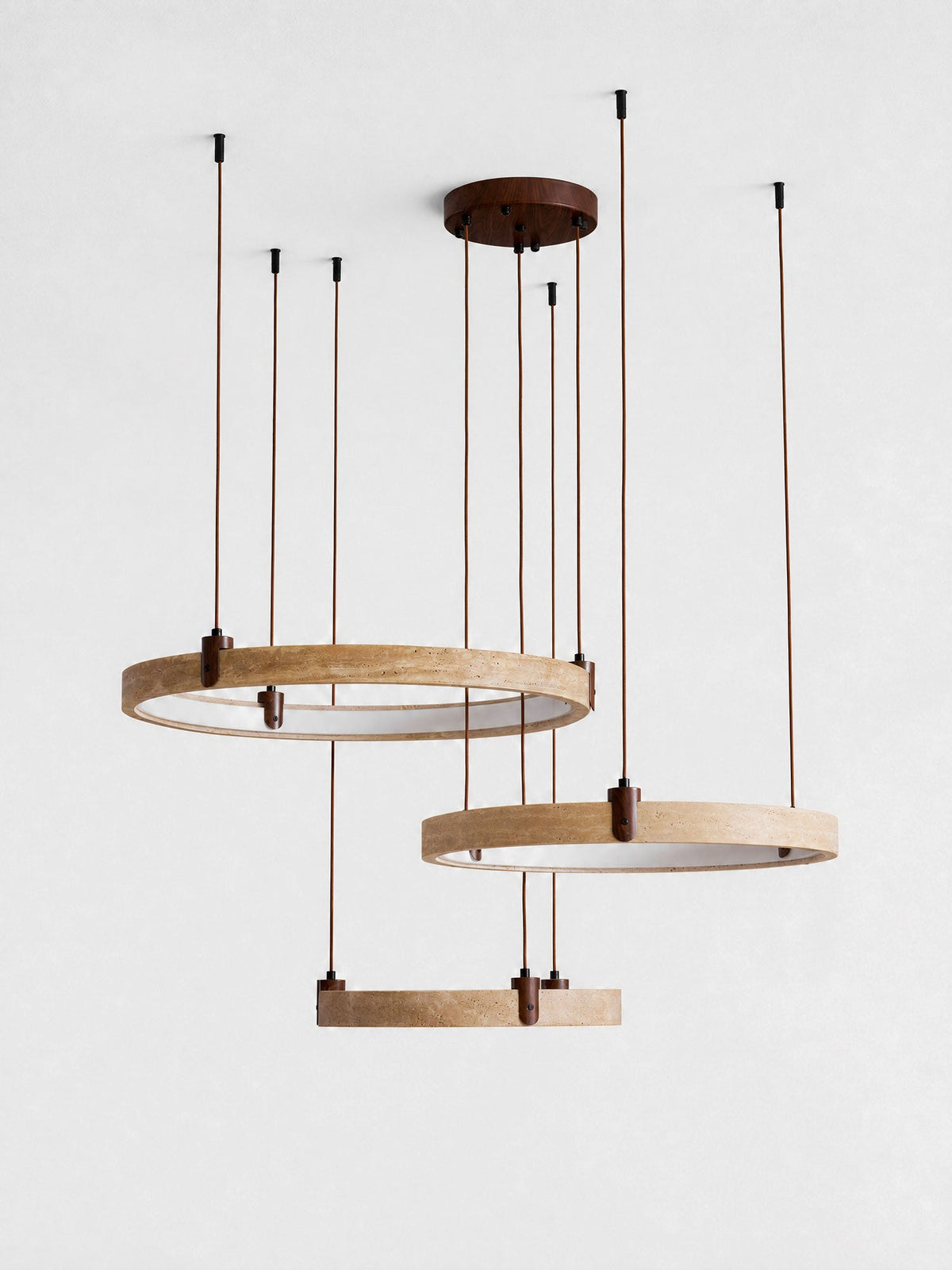 Three travertine rings with white inner faces hang from a round canopy on this Clérachic pendant, against a pale grey backdrop.