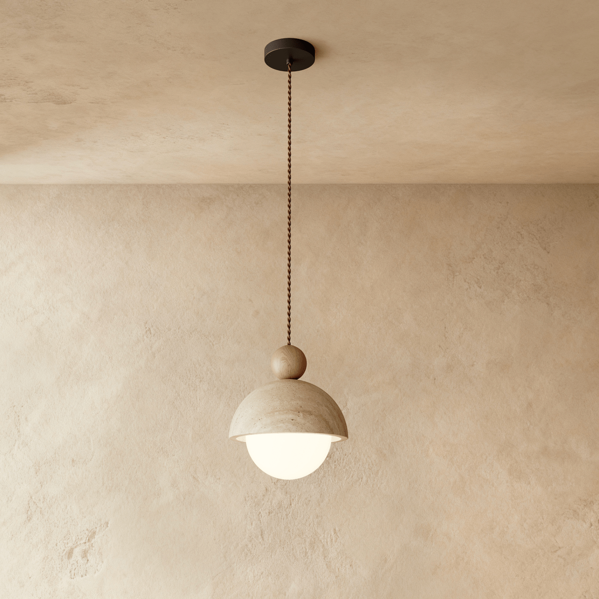 A front view of the Clérachic pendant light's stone dome shade and dark walnut ball against a plaster wall.