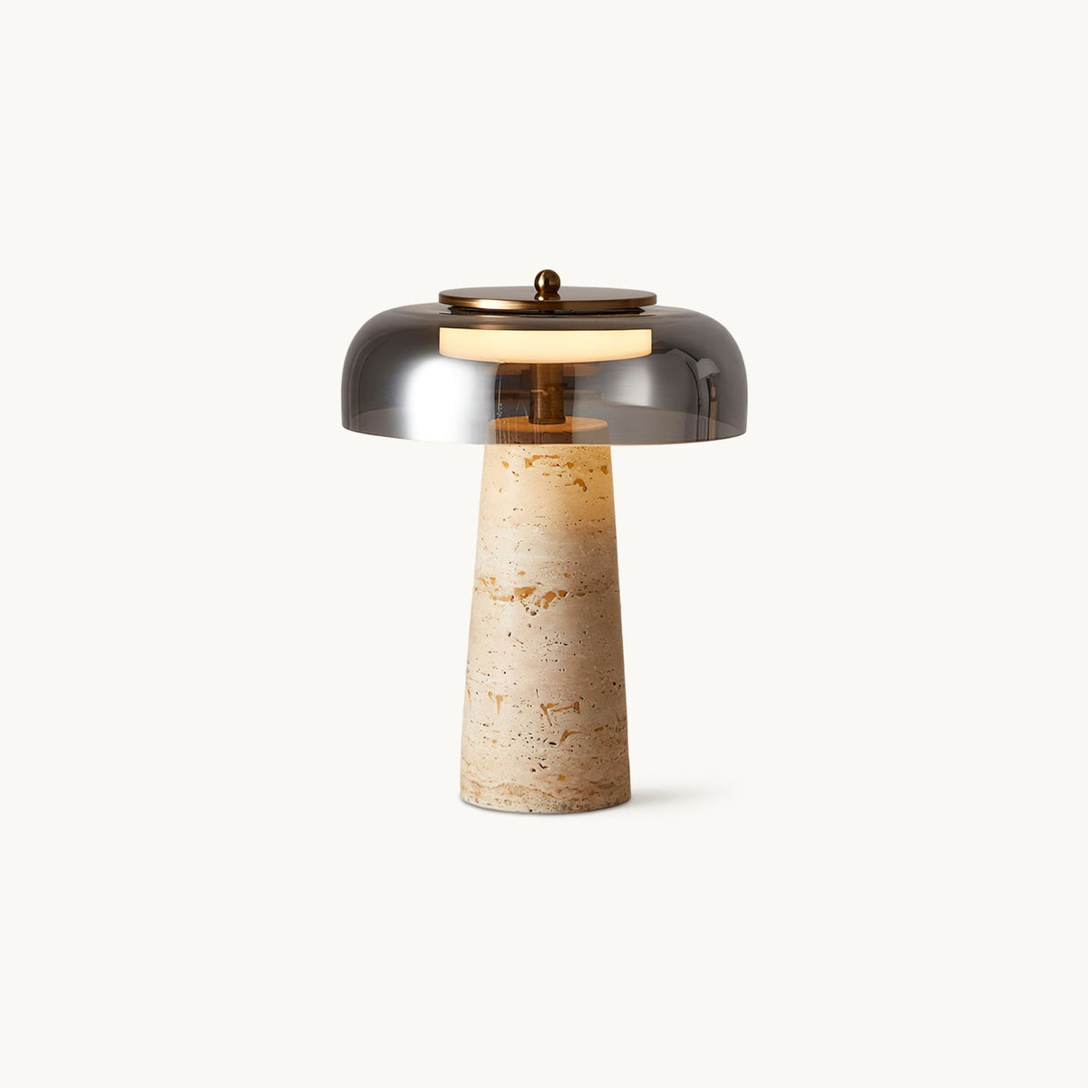 This Clérachic table lamp on a plain white backdrop, a smoky grey glass dome above a tapered beige travertine base.