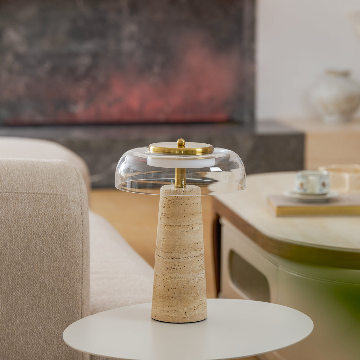 Small clear-dome Clérachic table lamp on a round white side table, a cream armchair and a low oval coffee table behind it.