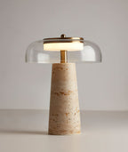 Clear glass dome and brass finial on this Clérachic table lamp, the lit ring of light glowing over a travertine base.