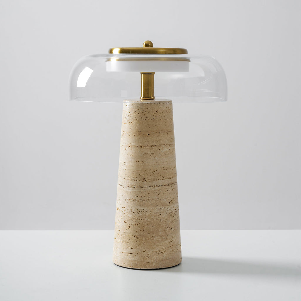 Clérachic table lamp with a clear glass dome set slightly off-centre over a brass stem and a pale banded travertine base.