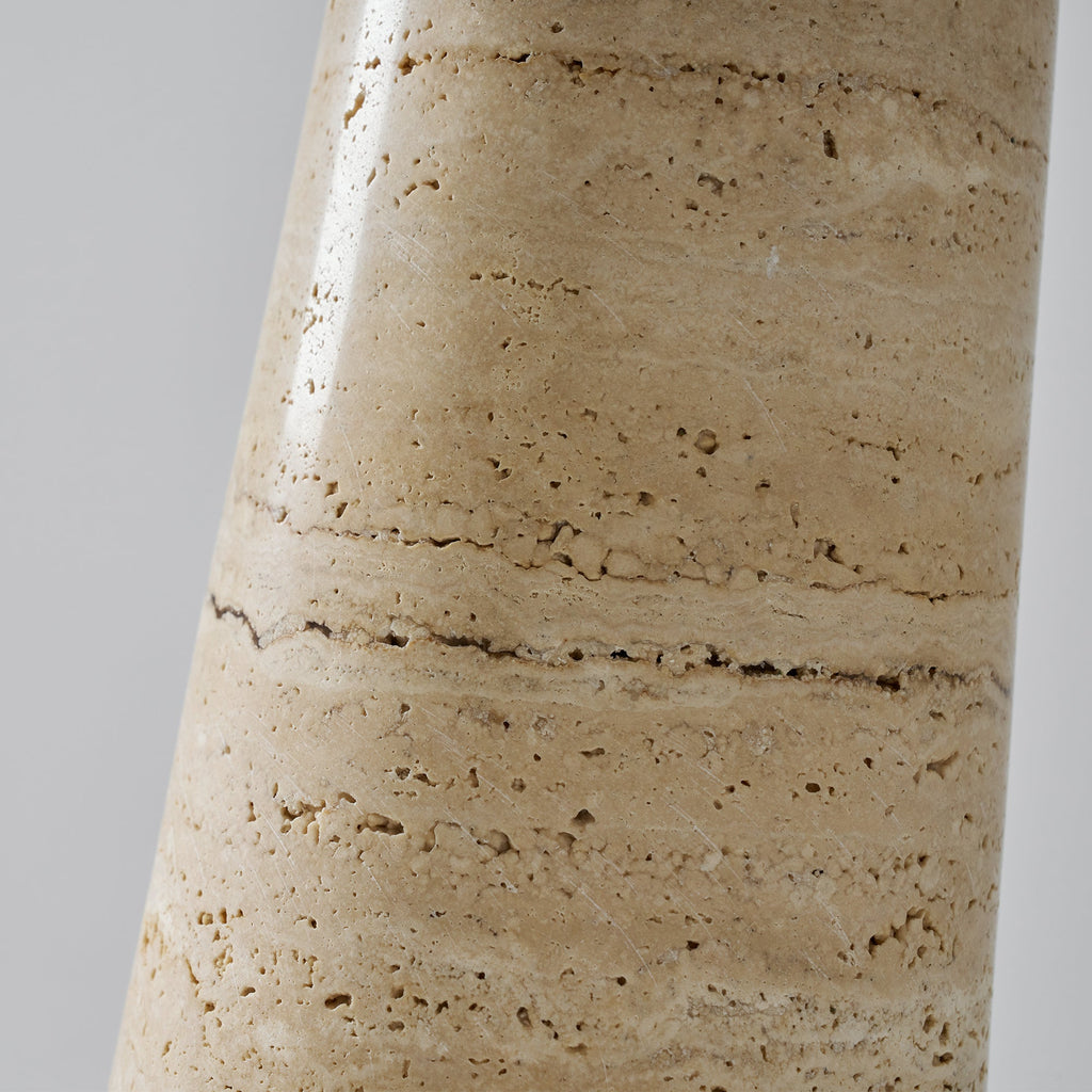Close view of the banded, pitted travertine on the base of this Clérachic table lamp, with fine dark veining running across it.
