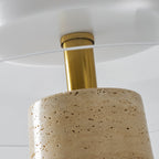 Close view of the brass collar where the stem meets the travertine base of this Clérachic table lamp, under the glass dome.