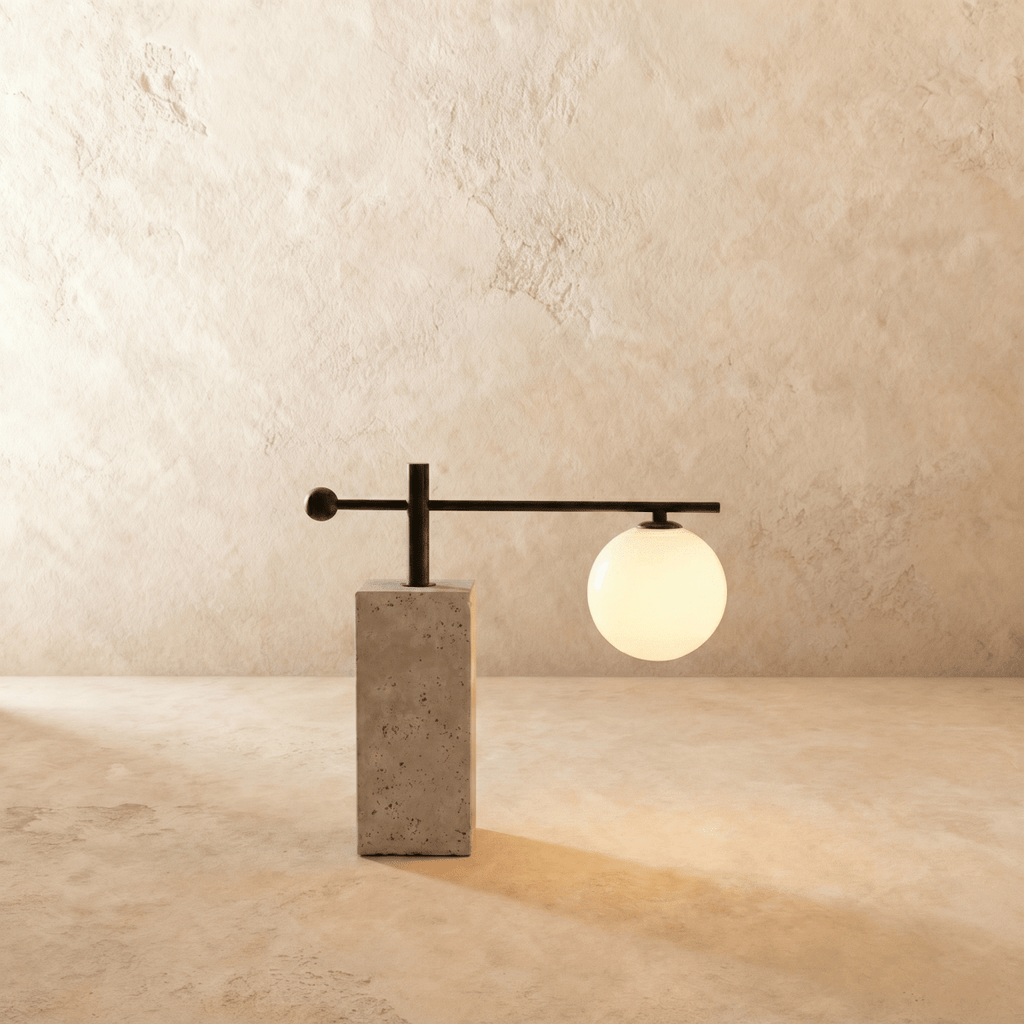 This Clérachic table lamp balances an opal glass globe on a slender black arm above a concrete block base.