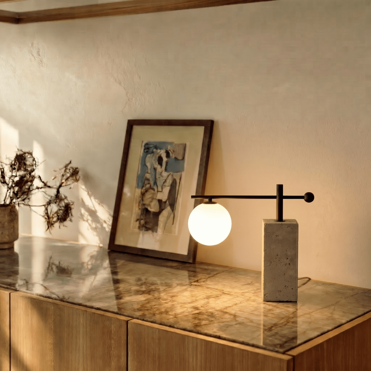 A Clérachic table lamp glows on a marble-topped console beside a framed abstract painting.
