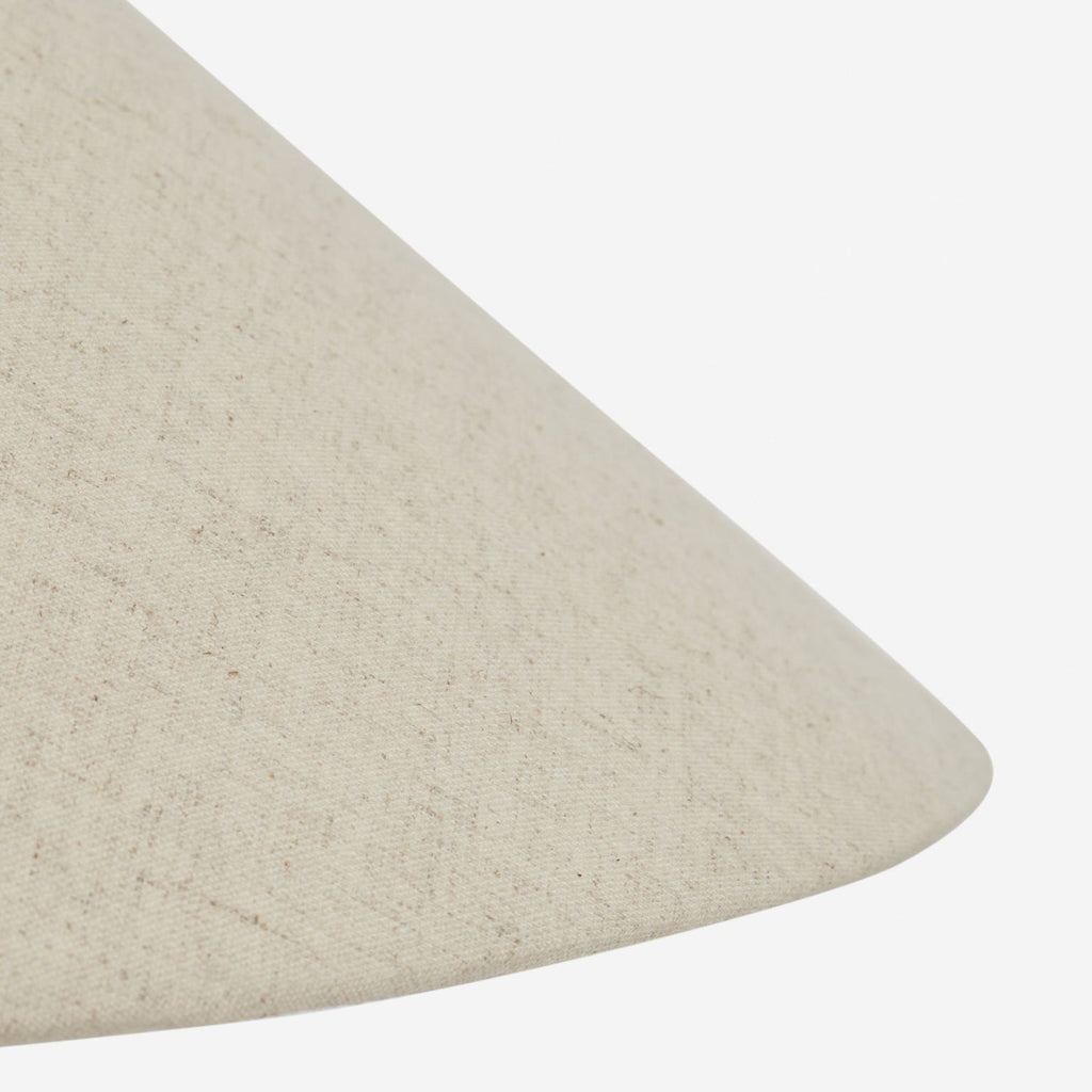 Close view of the sloping edge of the beige linen shade on this Clérachic table lamp, its fine woven texture clear.