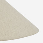 Close view of the sloping edge of the beige linen shade on this Clérachic table lamp, its fine woven texture clear.