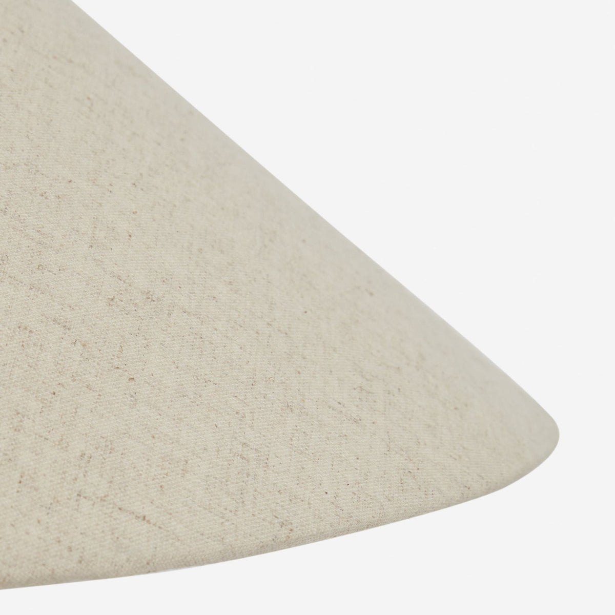 Close view of the sloping edge of the beige linen shade on this Clérachic table lamp, its fine woven texture clear.
