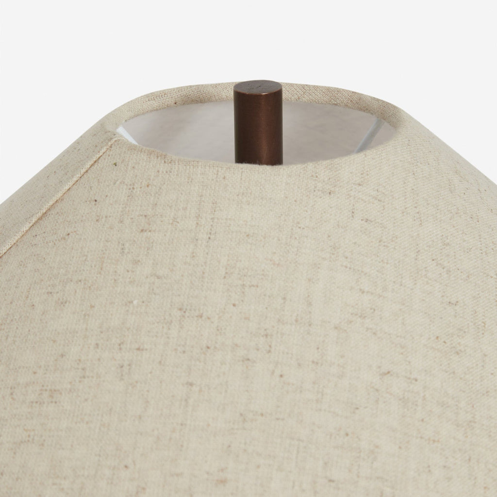 Looking up into the top of this Clérachic table lamp's linen shade, a dark metal finial and the woven texture of the fabric in view.