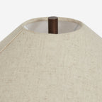 Looking up into the top of this Clérachic table lamp's linen shade, a dark metal finial and the woven texture of the fabric in view.