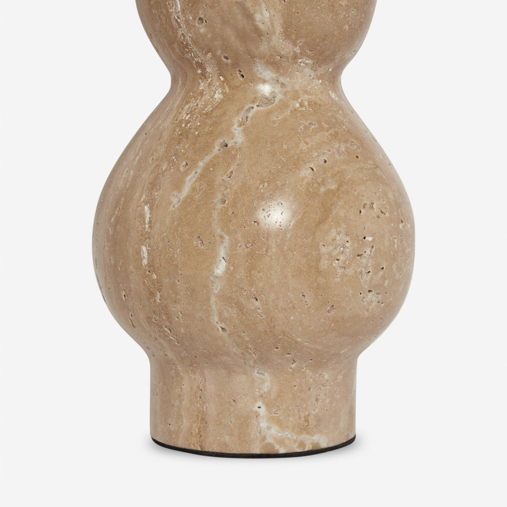 Close view of the rounded travertine base of this Clérachic table lamp, its veining and small natural pits clear.