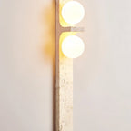 Clérachic travertine wall lamp seen at a slight distance, two lit globes above a long, softly veined cream stone bar.