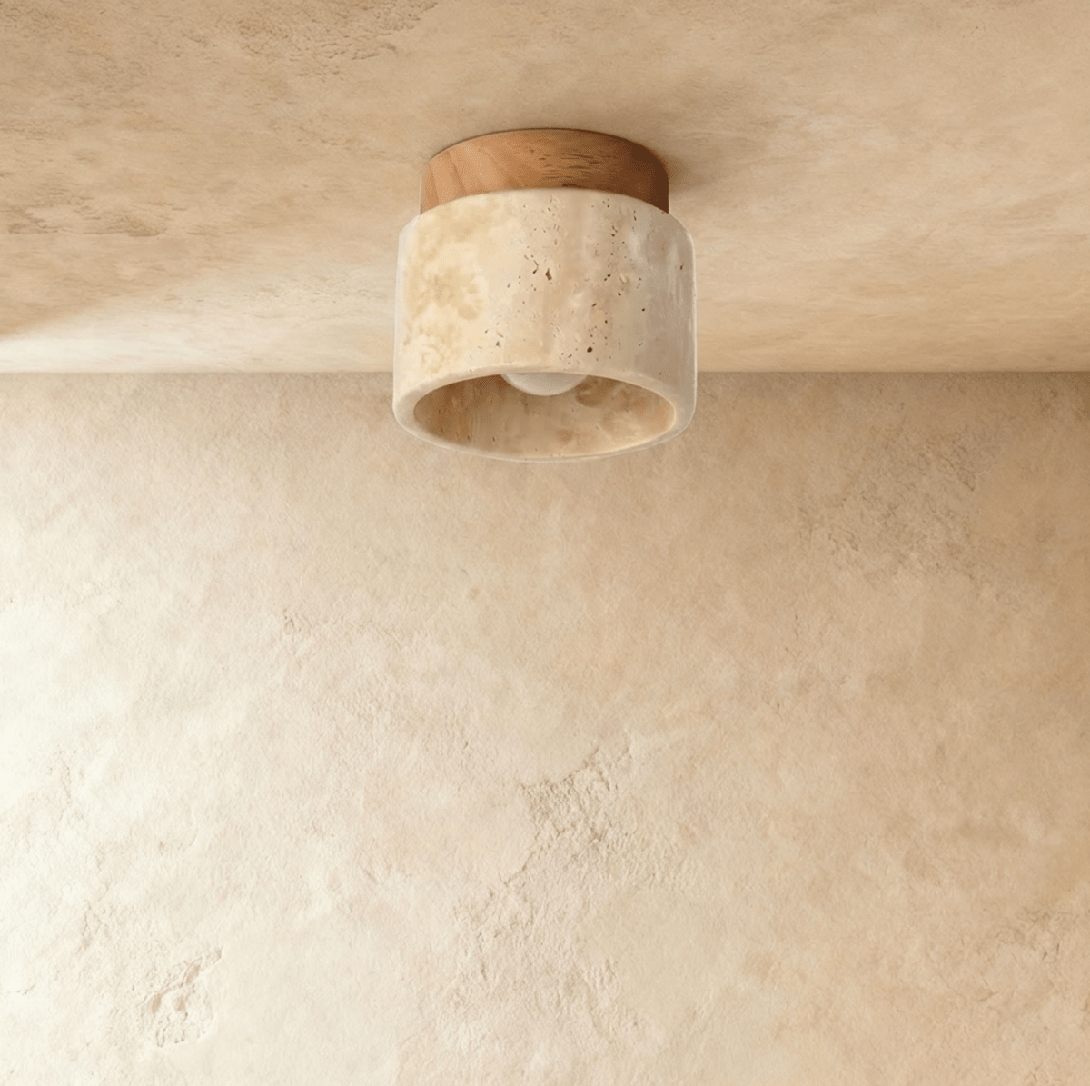 Clérachic short travertine ceiling light with a pale wood canopy, switched off to show the pitted stone and bare bulb inside.