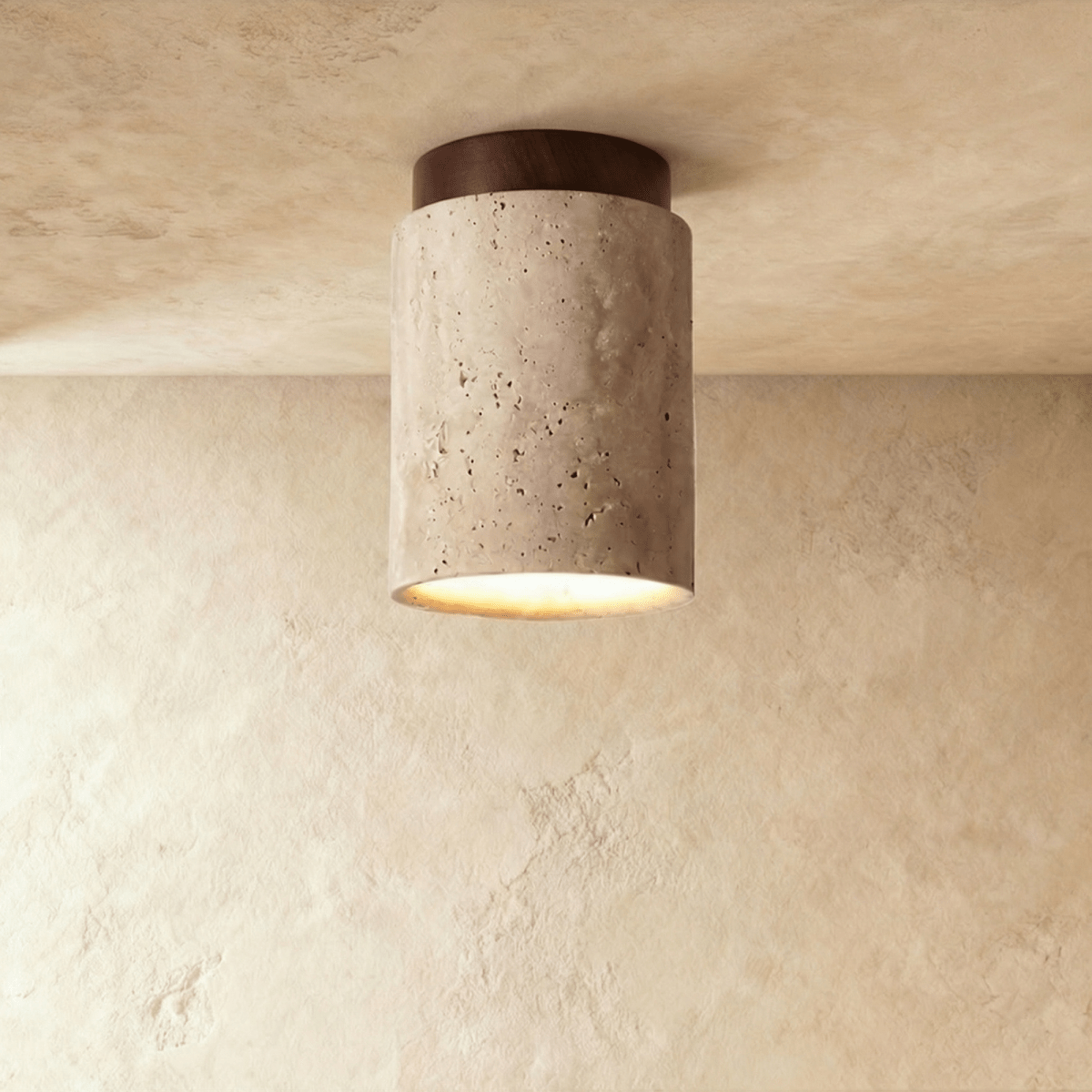 Clérachic tall travertine cylinder ceiling light with a dark walnut canopy against a limewashed plaster ceiling.