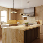 Three Clérachic pendants hang at staggered heights over a golden travertine island in a warm wood kitchen.