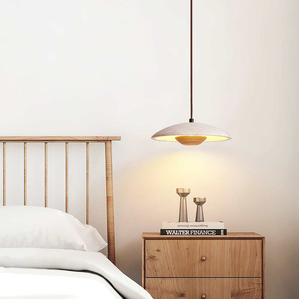 Above a wooden bedside chest and slatted headboard, a Clérachic travertine pendant lights the wall below it.