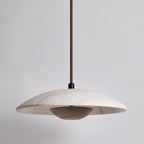 Clérachic pendant in veined travertine with a dark walnut-toned bowl beneath, shown unlit on a grey backdrop.