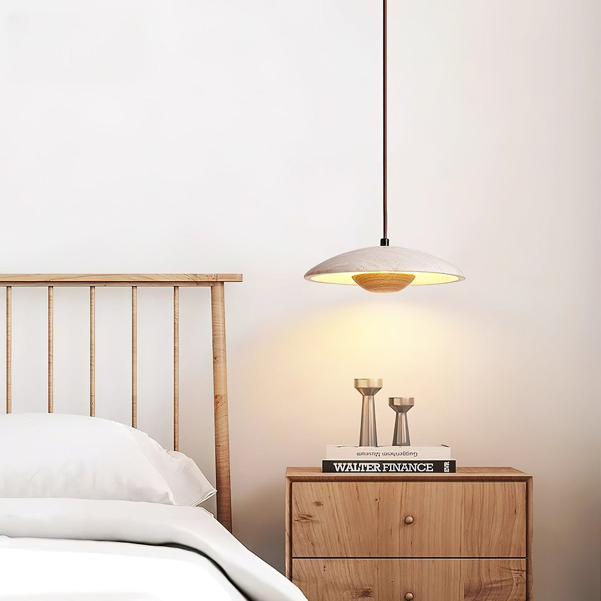 Above a slatted headboard and oak bedside chest with candle holders, a Clérachic travertine pendant glows softly.