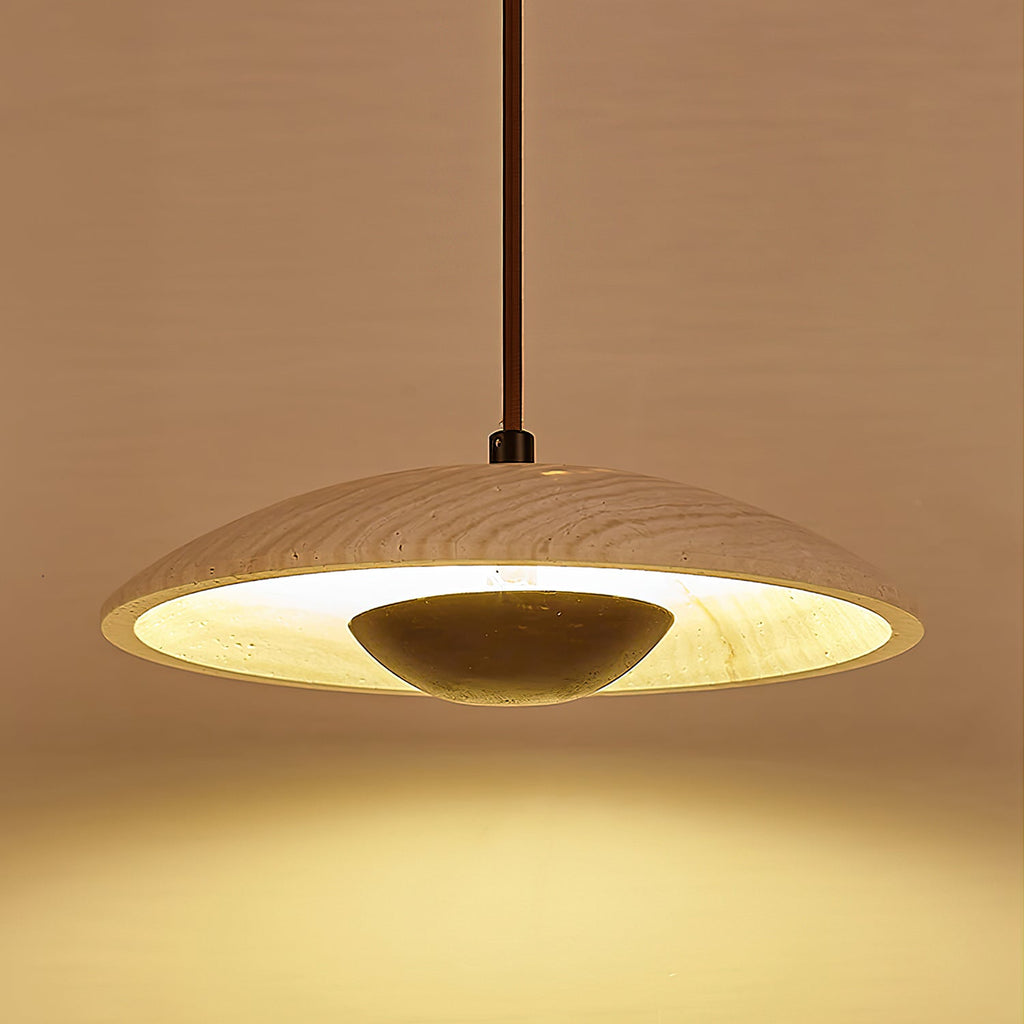 Underside view of a Clérachic pendant, with a rim of warm light around the stone shade and a dark bowl in the middle.