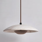 Clérachic pendant with a travertine shade and a dark walnut-toned bowl, shown unlit against a soft grey wall.