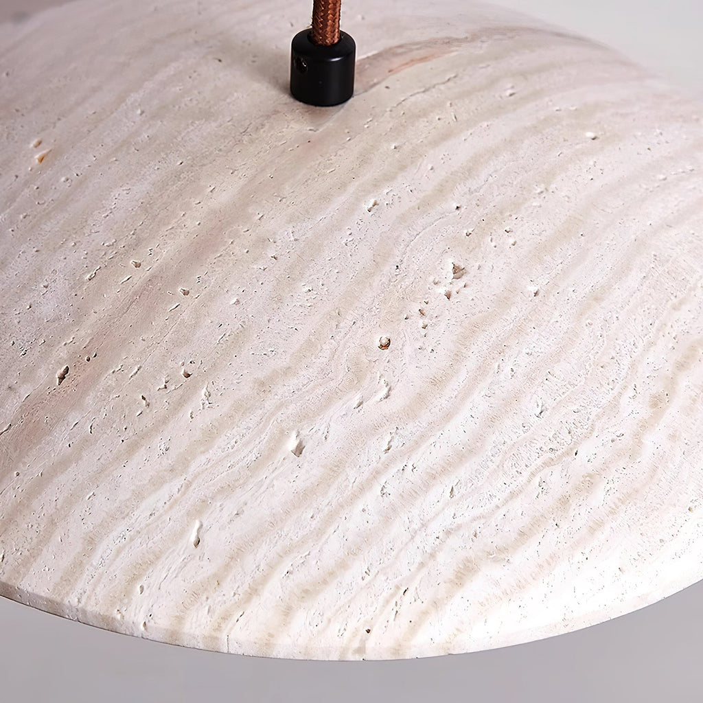 Close view of the veined surface and fabric cord entry at the top of this Clérachic pendant's travertine shade.