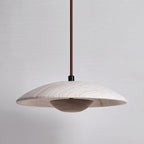 Clérachic pendant with a veined stone shade and a dark walnut-toned bowl, shown against a cool grey backdrop.