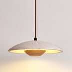 Clérachic pendant with a light wood bowl and a banded stone shade, lit warm, seen from a slightly low angle.