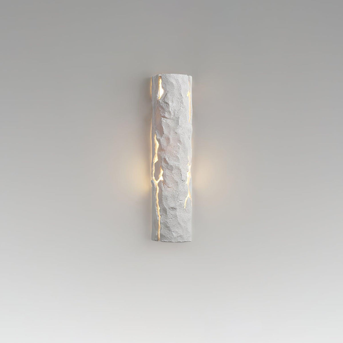 A white Clérachic wall light on a grey gradient backdrop, with a soft halo of warm light on either side of its cracked surface.