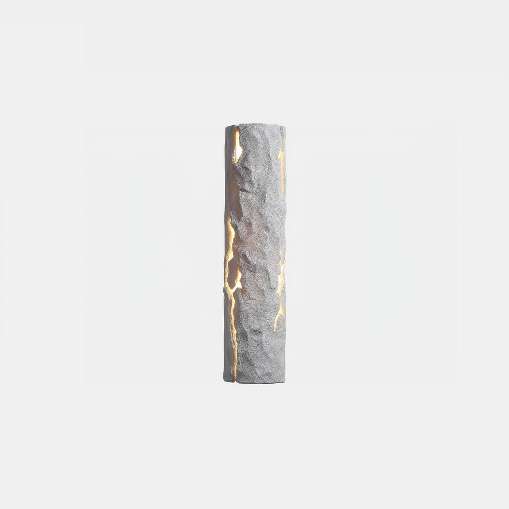 A white Clérachic wall light with a chiselled, cracked surface and light shining through the fissures, on a pale backdrop.
