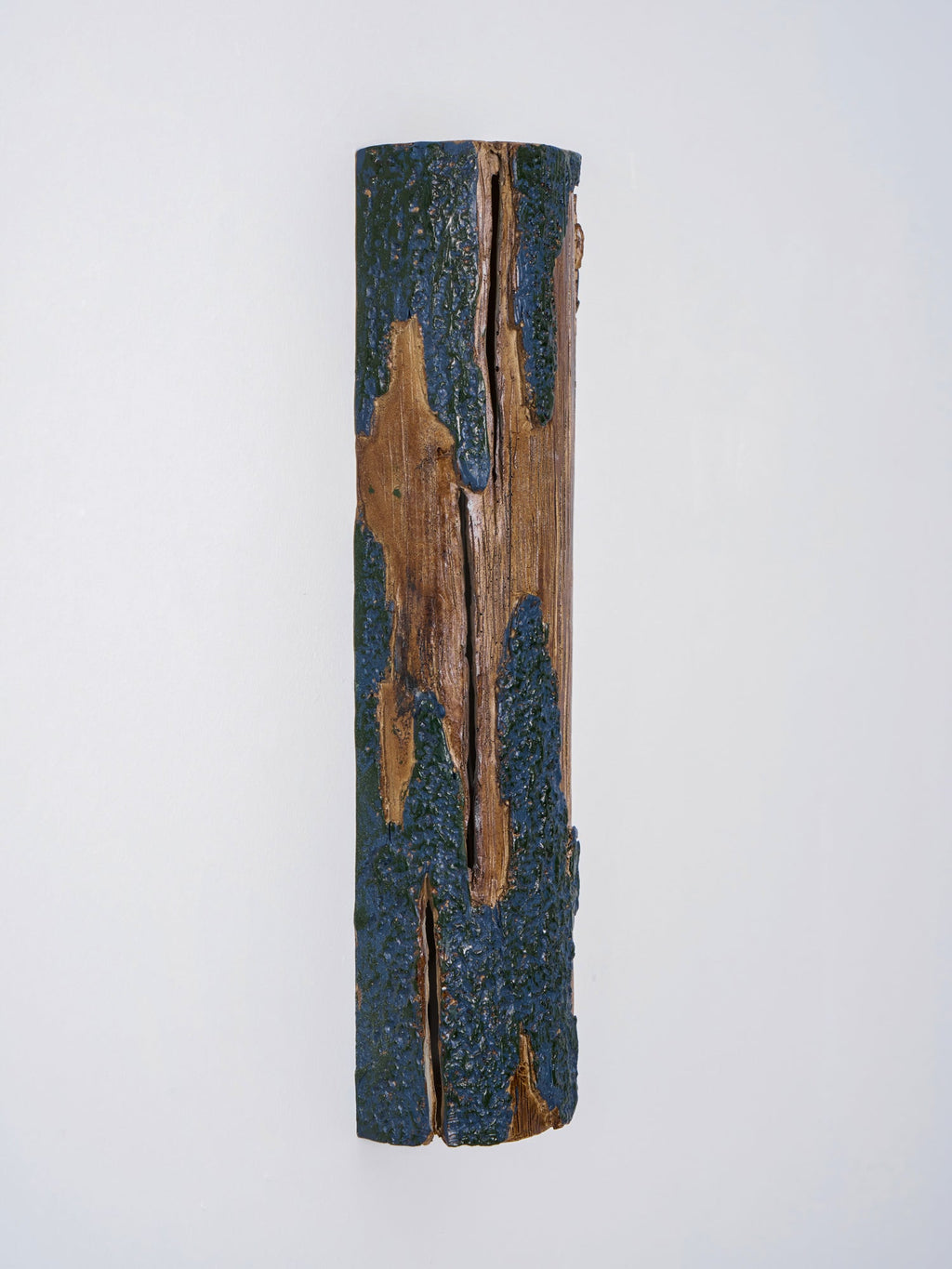 Front view of a Clérachic Bark wall light with a split down the wood and rough blue-grey bark along each edge.