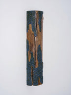 Front view of a Clérachic Bark wall light with a split down the wood and rough blue-grey bark along each edge.