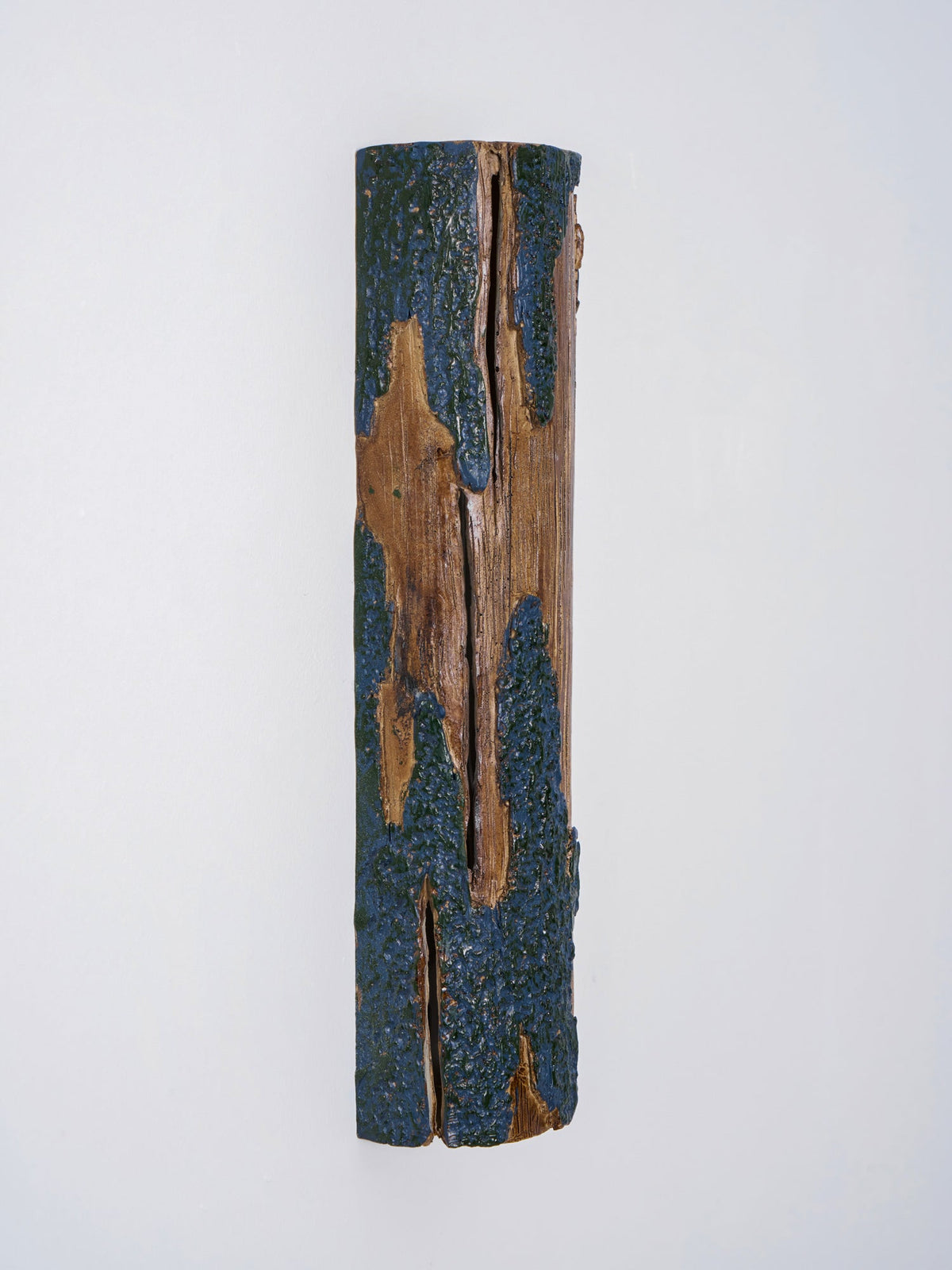 Front view of a Clérachic Bark wall light with a split down the wood and rough blue-grey bark along each edge.