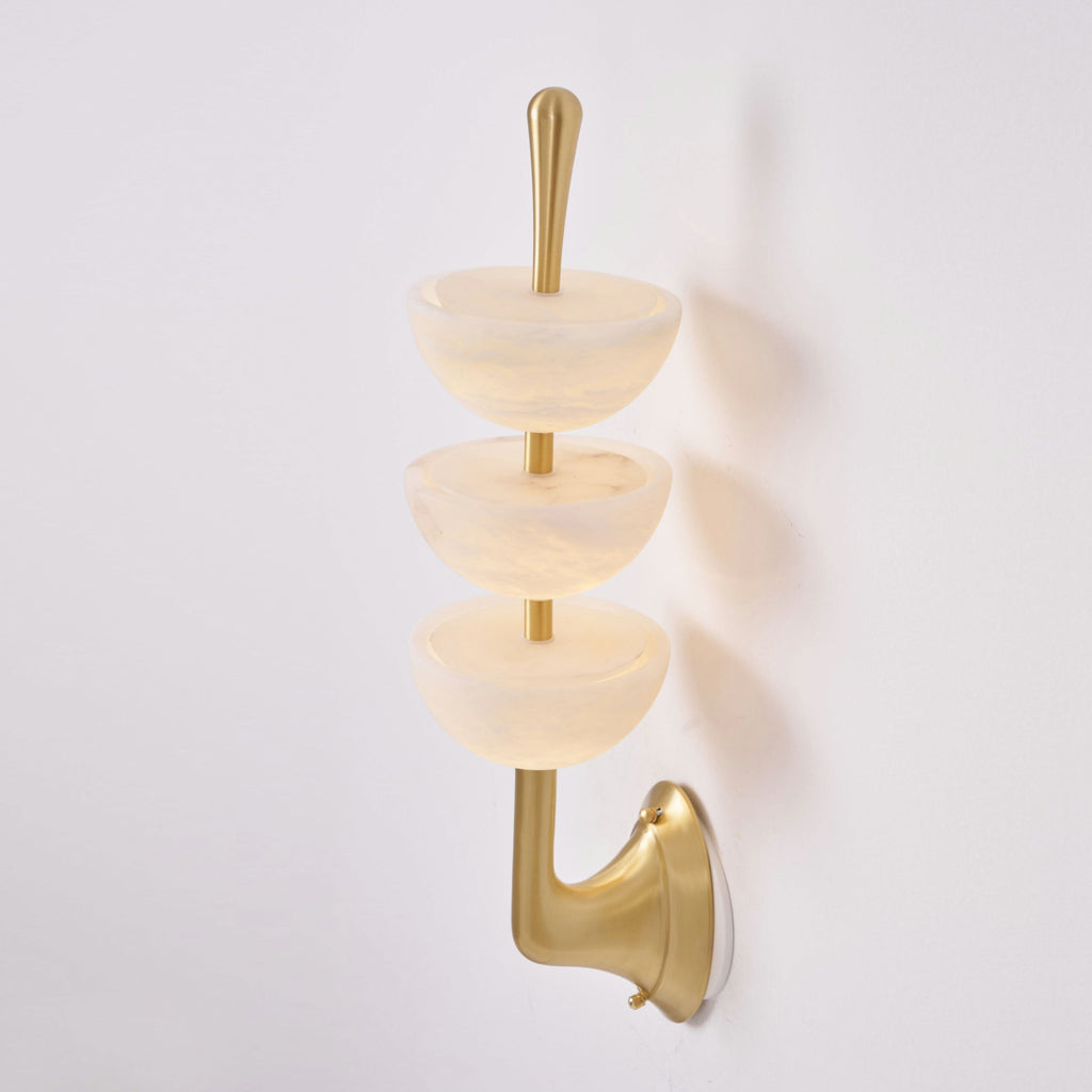 Clérachic triple-dome wall sconce seen from below, the open alabaster bowls showing the hollows that throw light up the wall.