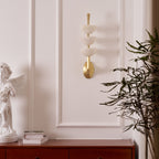 Clérachic alabaster wall sconce on a panelled wall above a wooden sideboard, narrow enough for the space beside the moulding.