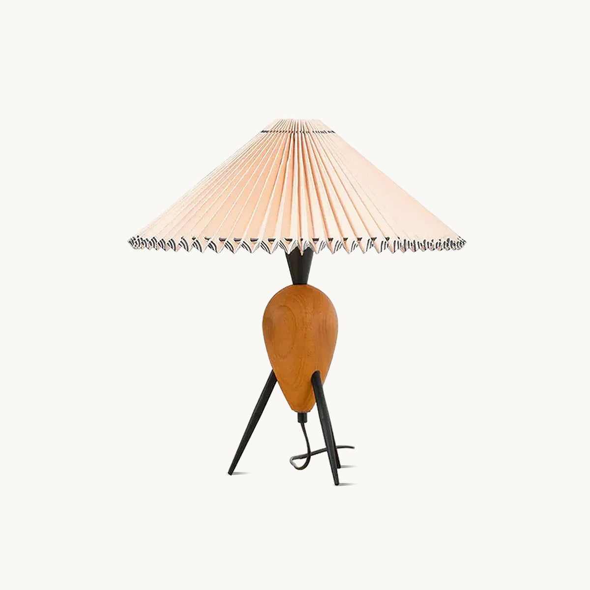 This Clérachic table lamp on a plain white backdrop, a pleated beige shade over a turned wood base and black tripod legs.